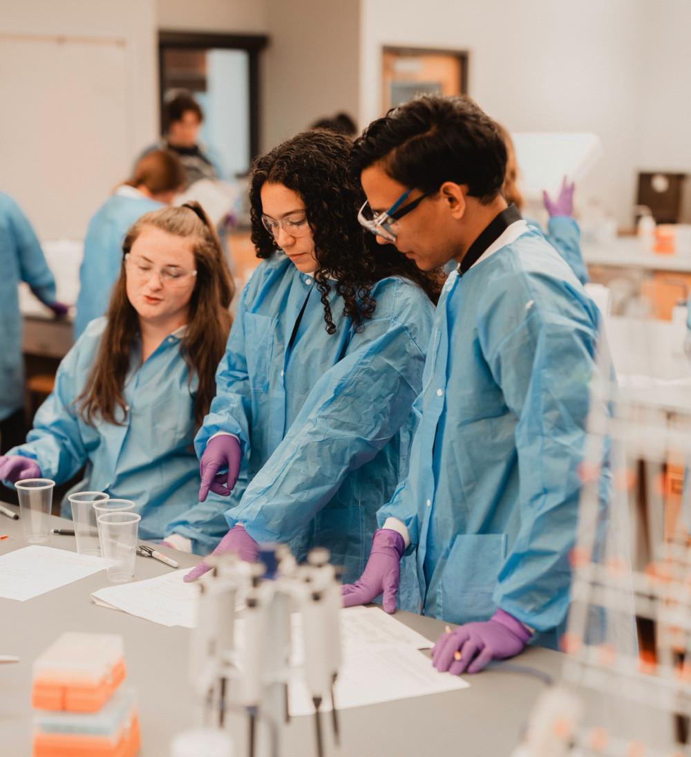 Three students participating in a cell biology lab session.